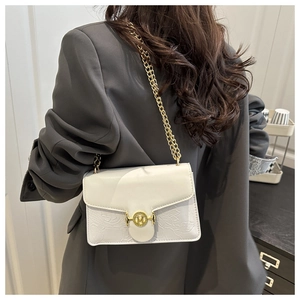 Close-up of white PU leather crossbody bag with embossed texture and gold M hardware