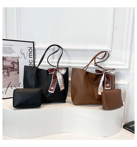 Detail view of black and brown tote bags with matching pouches and printed silk scarves