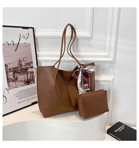 Brown leather tote bag detail with decorative silk scarf and matching small pouch