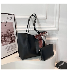 Detail of minimalist black matte leather tote bag set with decorative scarf and small pouch