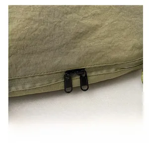 Détail des doubles fermetures éclair en métal et du tissu en nylon de ce sac bandoulière