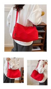 Détail du grand sac bandoulière en nylon rouge avec broderie et sangle réglable