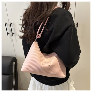 Macro detail of pink pleated texture and metal ring connection on the shoulder bag
