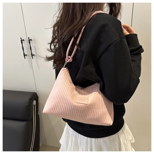 Detail of pink pleated stripe shoulder bag showing delicate fabric texture and logo plate