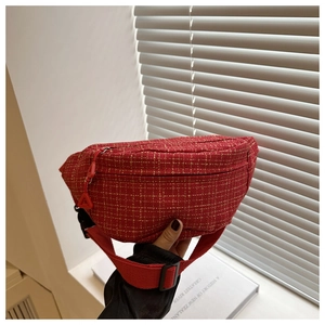 Detail of red checkered tweed waist bag with textured fabric and adjustable strap