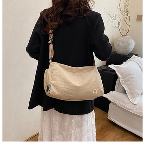 Détail d'un sac cabas beige en nylon avec étiquette Fashion et logo FY porté à l'épaule