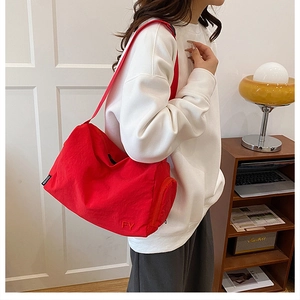 Détail du sac bandoulière en nylon rouge avec broderie FY et étiquette latérale mode