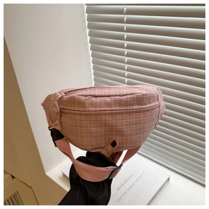 Detailed macro of pink tweed waist bag featuring classic checkered texture and triangular zipper