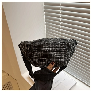 Detailed close-up of black and white tweed check waist bag with adjustable strap