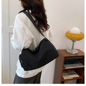 Vue détaillée du sac bandoulière cylindrique noir en nylon avec logo FY et sangle réglable