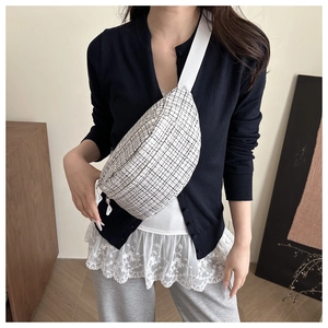 Detail view of monochrome plaid texture on fashion crossbody chest bag with fabric strap