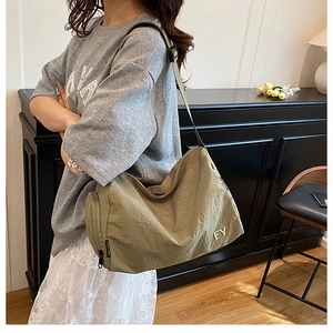 Détail du sac bandoulière en nylon kaki avec poche latérale zippée et logo FY