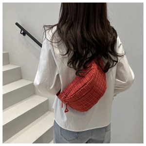 Back view of a model wearing the red plaid tweed saddle bag as a stylish crossbody pack