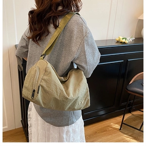 Détail de la bandoulière et broderie FY sur ce sac décontracté en nylon kaki léger