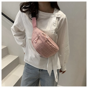 Detail of pink plaid waist bag with adjustable strap worn as a crossbody chest bag