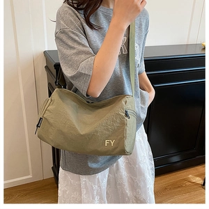 Sac bandoulière en nylon vert olive avec bandoulière réglable et logo métallique