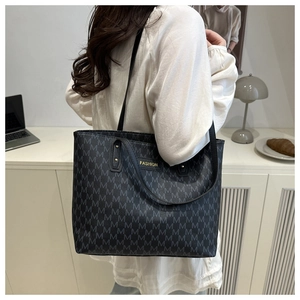 Détail d'un sac cabas noir avec imprimé monogramme M et plaque métallique dorée Fashion