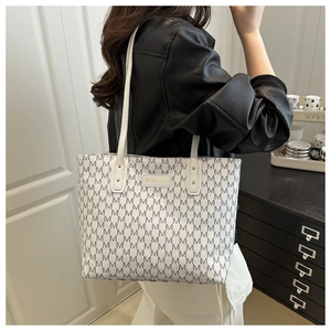 Détail du grand sac cabas blanc avec monogramme M et plaque métallique dorée