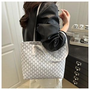 Détail du sac cabas blanc avec motif M gris et étiquette Fashion sur l'épaule