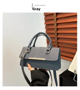 Detail of black textured fabric handbag with elegant gold metal buckle and top handle