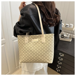 Détail du grand sac cabas à monogramme avec motif M beige et plaque dorée