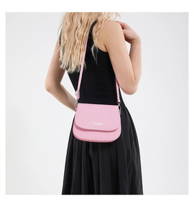 Detail of pink saddle bag with textured finish and Fashion Trend EST. 1996 branding