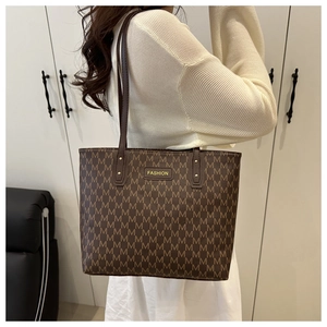 Détail d'un grand sac cabas marron avec motif M imprimé et étiquette FASHION jaune