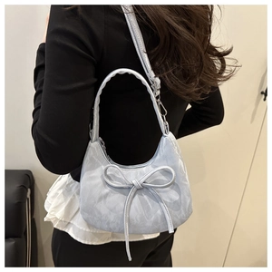 Détail du sac à main bleu clair avec nœud décoratif et texture effet marbre élégant
