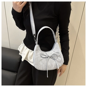 Détail du sac à main bleu clair à nœud avec texture froissée et garnitures argentées