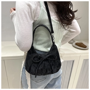 Sac à bandoulière noir avec nœud porté par un mannequin pour le style et la taille
