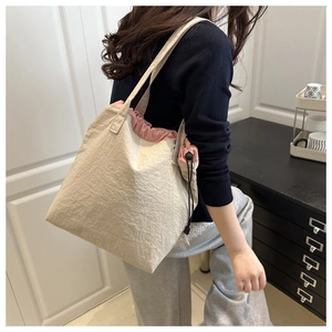 Detail of drawstring tote bag showing beige cotton fabric and pink lining closure