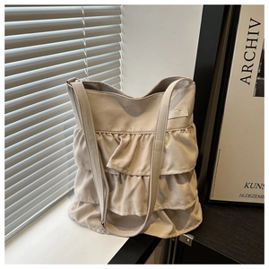 Detail shot of multi-layered beige ruffle tote bag with textured oxford fabric finish