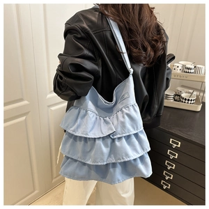 Detailed back view of a light blue ruffle tote bag with tiered canvas folds and strap