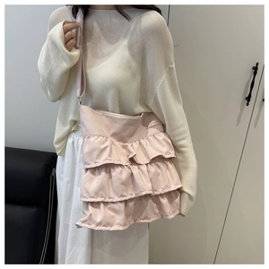 Detailed view of layered ruffle design and brand label on pink oxford tote bag