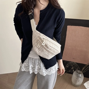 Minimalist beige tweed saddle bag with wide shoulder strap and woven texture