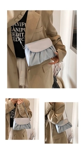 Detail of light blue pleated cloud bag featuring a silver metal chain and soft texture