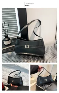 Detail of minimalist black leather baguette bag with premium golden square metal buckle