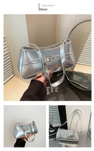 Detail view of silver metallic underarm bag with decorative strap buckle and sleek texture