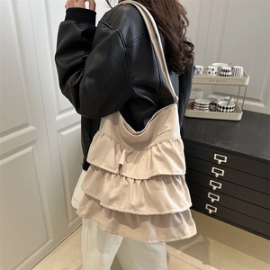 Chic beige canvas tote bag featuring triple ruffle layers and adjustable crossbody strap