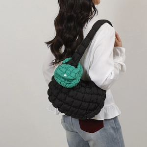 Chic black quilted puff shoulder bag for women with a green mini charm on a shoulder strap