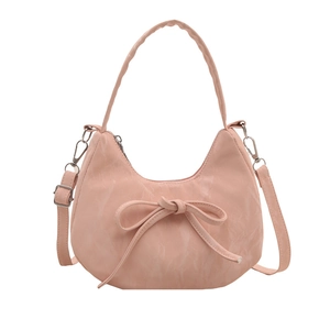 Pink crescent moon underarm bag with decorative bow and textured faux leather finish