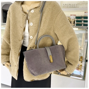 Detail of grey-purple suede tote bag with metallic bar buckle and textured finish