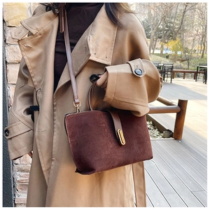 Close-up of the vintage brown tote bag showing its suede texture and gold metal buckle