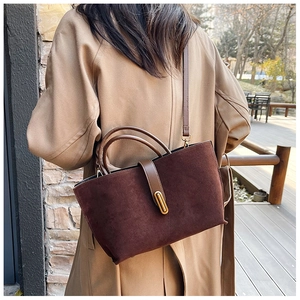 Detail of vintage matte suede tote bag in dark brown with elegant gold metal lock buckle