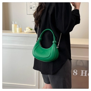 Detail of bright green hobo bag featuring a thick handle and silver chain strap
