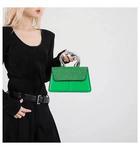 Détail d'un mini sac à main vert avec rabat pailleté et poignée en métal liquide