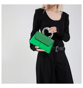 Détail du sac à main vert néon avec poignée en argent et texture pailletée