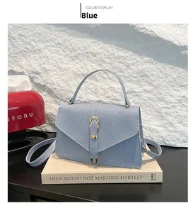 Detailed close-up of light blue small square bag with woven texture and metal clasp