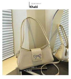 Detail view of khaki woven baguette bag with metal bow buckle and dual strap options
