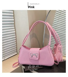 Detailed view of a pink textured baguette bag featuring a silver metal bow buckle accent
